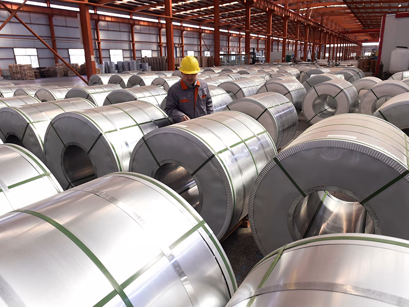 FILE PHOTO: A worker checks aluminium rolls at a warehouse inside an industrial park in Binzhou